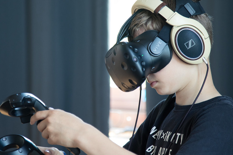 Junger Mensch mit VR Brille und Kopfhörern auf dem Kopf